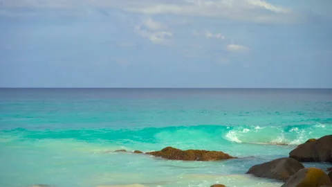 Beautiful sandy beach with blue sky and ocean waves on an exotic island Stock Footage 107510080