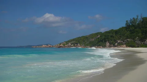 Beautiful sandy beach with blue sky and ocean waves on an exotic island Stock Footage 107510122