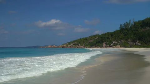 Beautiful sandy beach with blue sky and ocean waves on an exotic island Stock Footage 107510145