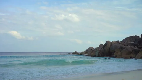 Beautiful sandy beach with blue sky and ocean waves on an exotic island Stock Footage 107854101