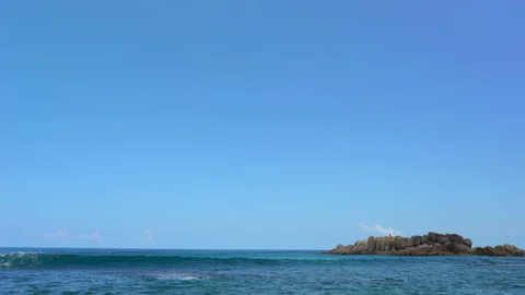 Beautiful sandy beach with blue sky and ocean waves on an exotic island Stock Footage 109256148