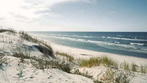 A beautiful sandy beach features a large body of water in the background Stock Photos