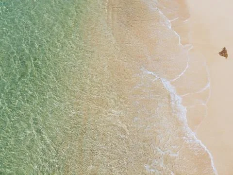 Beautiful sandy beach with turquoise water and soft blue foaming ocean wave Stock Photos