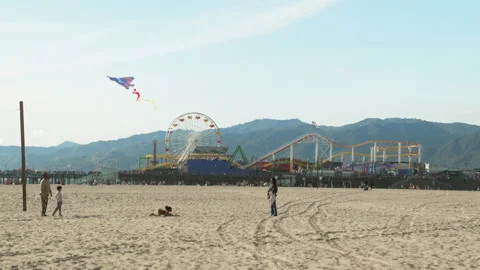 Beautiful scene: Family flies kite on Santa Monica Beach against Pier &amp; Stock Footage 133851663