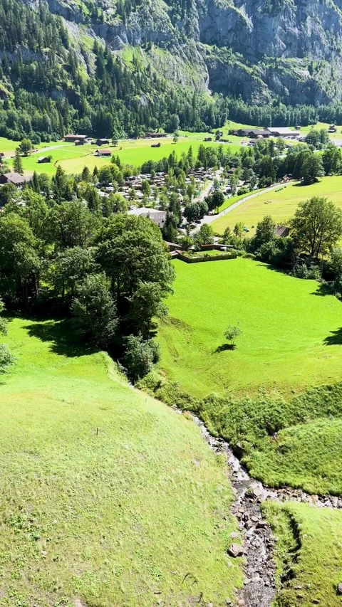 A beautiful scene featuring lush green fields and a peaceful stream in a lovely Stock Footage 304782086