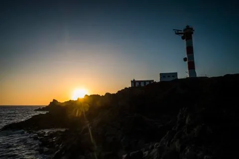 Beautiful scenic landscape with classic lighthouse and golden sunset in backg Foto stock