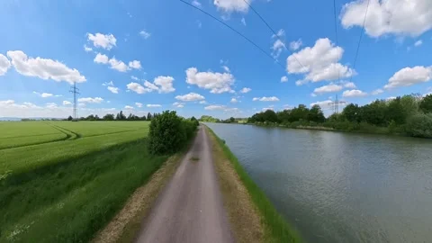A Beautiful Scenic River Pathway Beneath a Bright Blue Sky Filled with Fluffy Stock Footage 305571558