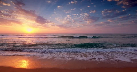 Beautiful sea sunrise with sun rays and soft splashing waves on beach shore Stock Footage 334429342