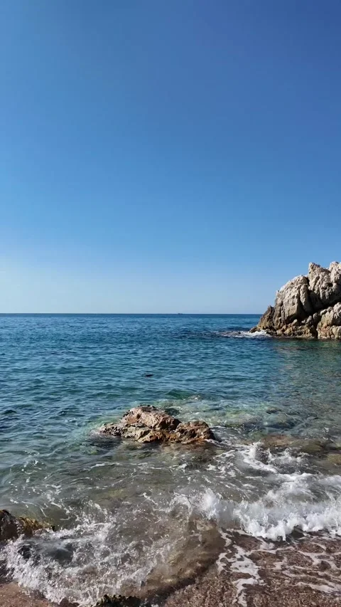 Beautiful sea view on an empty rocky beach with blue sky, vertical background Stock Footage 277148251