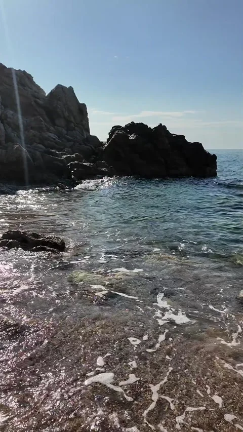 Beautiful sea view on an empty rocky beach with blue sky, vertical background Stock Footage 277148253