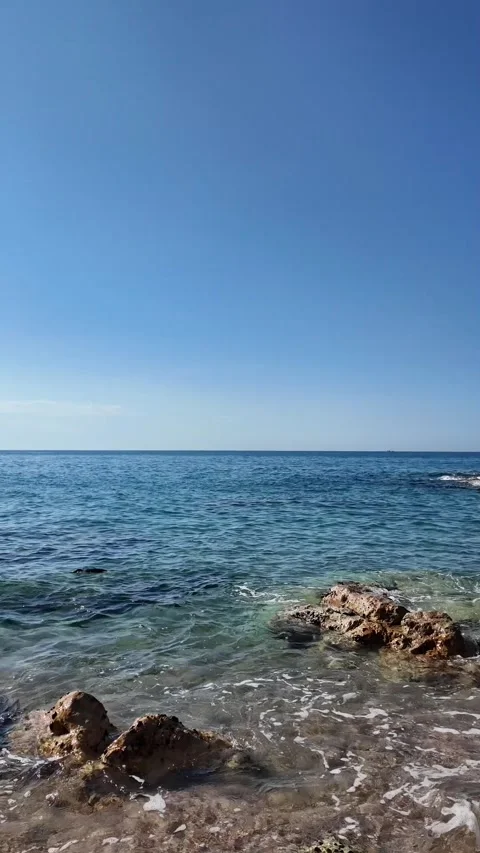 Beautiful sea view on an empty rocky beach with blue sky, vertical background Stock Footage 277148273