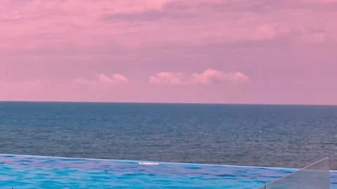 Beautiful sea view from the Infinity swimming pool and sunset pink blue sky colo Stock Footage 320941971
