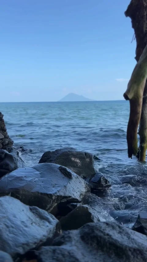Beautiful sea waves hitting rocks in middle of sunny day. Vertical View Stock Footage 290260967