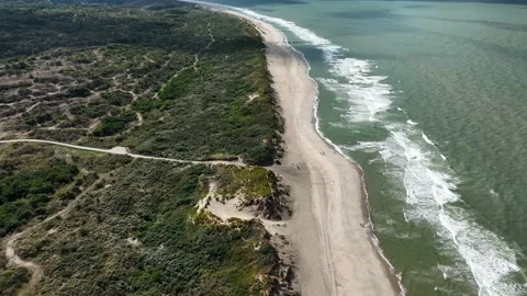 A beautiful secluded beach with rolling waves and overgrown dunes as seen Stock Footage 217440711