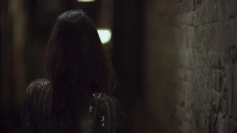 Beautiful seductive Italian model posing in her dress and walking down a dark al Stock Footage 199463511