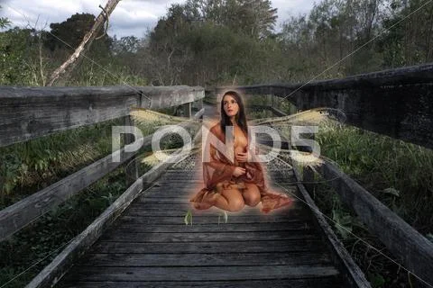 Beautiful seminude fairy on a forest boardwalk Stock Photos