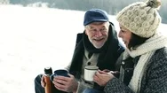 Beautiful Senior Couple On Sledge Drinking Tea, Winter Day. Stock Footage