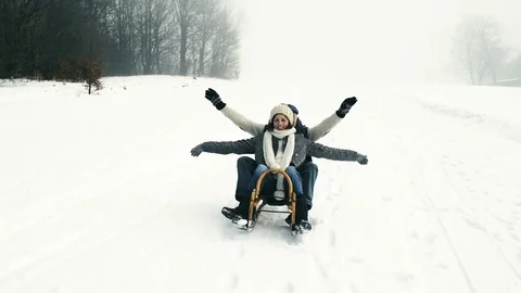 Beautiful senior couple on sledge having fun, winter day. Stock Footage 80248800