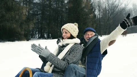 Beautiful senior couple on sledge having fun, winter day. Stock Footage 80852985