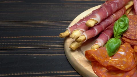 A beautiful serving board of bacon pastrami and sausage. Slow motion Stock Footage 133604428