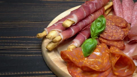A beautiful serving board of bacon pastrami and sausage. Slow motion Stock Footage 133604449