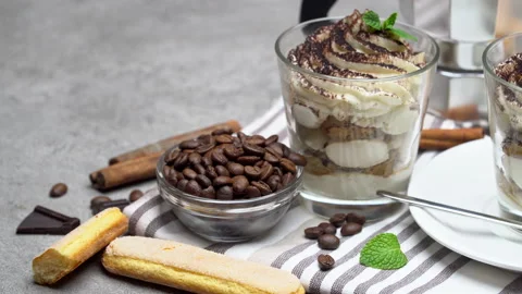 A beautiful serving table with tiramisu dessert and a cup of coffee been Stock Footage 133604709