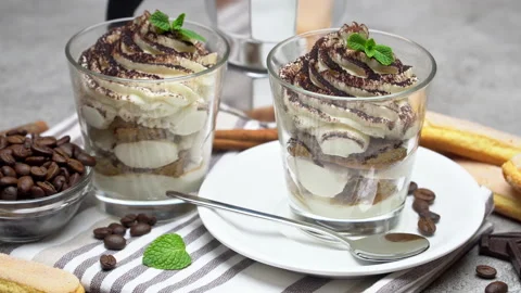 A beautiful serving table with tiramisu dessert and a cup of coffee been . Stock Footage 133604809