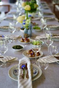 Beautiful setting of a large table with snacks and flowers. Stock Photos