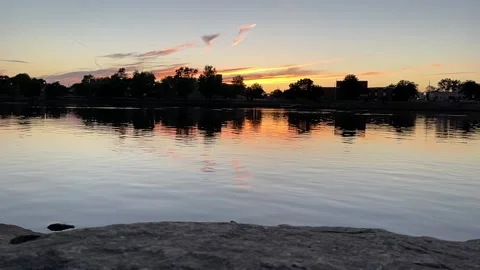 A beautiful setting sun casts an orange glow across the sky Stock Footage 155886479