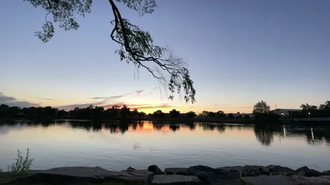 A beautiful setting sun casts an orange glow across the sky Stock Footage 155886675