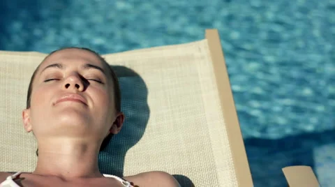 Beautiful sexy woman taking sunbath by the pool Stock Footage