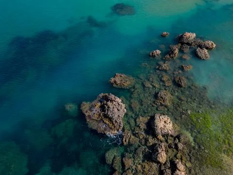 Beautiful sharp rocks formation in turquoise sea in Malta near the beach aerial Stock Photos