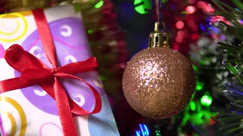 A beautiful shiny ball and a gift box hang from the tree. New Year's celebration Stock Footage 163091663