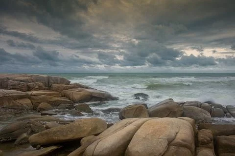 Beautiful shore and rain clouds with rocks on the beach Stock Photos
