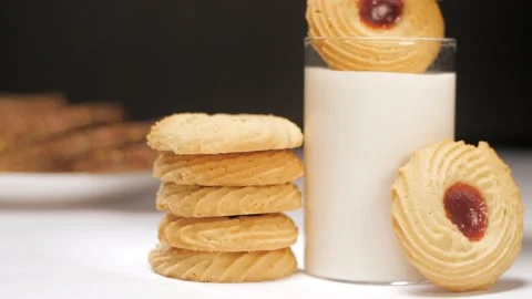 A beautiful shot of cookie topped with jam dipped in a glass of warm milk Stock Footage 197738422