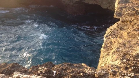 Beautiful Shot Of Deep Blue Waves Crashing Against Rock Cliff, Bali, Indonesia Stock Footage 104729189