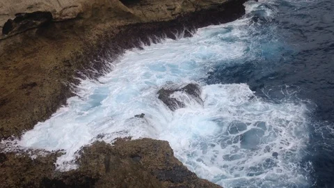 Beautiful Shot Of Deep Blue Waves Crashing Against Rock Cliff, Bali, Indonesia Stock Footage 104729200