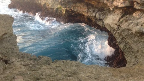 Beautiful Shot Of Deep Blue Waves Crashing Against Rock Cliff, Bali, Indonesia Stock Footage 104729232