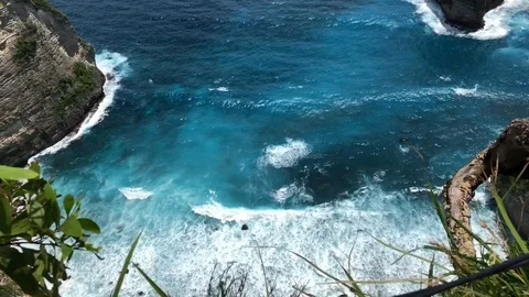 Beautiful Shot Of Deep Blue Waves Crashing Against Rock Cliff, Bali, Indonesia Stock Footage 115914989