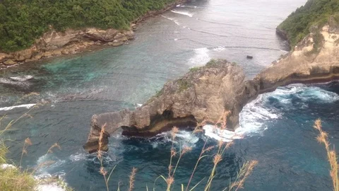 Beautiful Shot Of Deep Blue Waves Crashing Against Rock Cliff, Bali, Indonesia Stock Footage 115915109