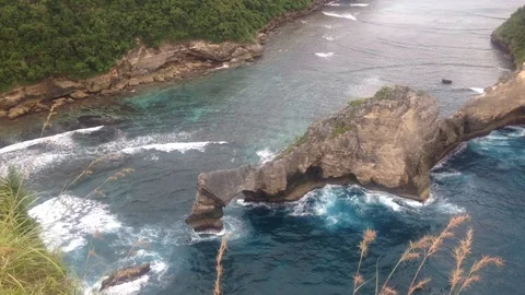 Beautiful Shot Of Deep Blue Waves Crashing Against Rock Cliff, Bali, Indonesia Stock Footage 115915114