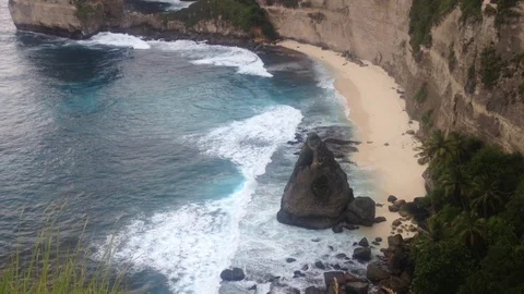 Beautiful Shot Of Deep Blue Waves Crashing Against Rock Cliff, Bali, Indonesia Stock Footage 115915135