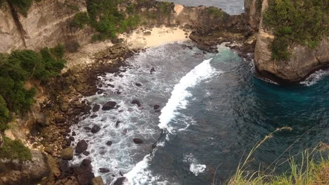 Beautiful Shot Of Deep Blue Waves Crashing Against Rock Cliff, Bali, Indonesia Stock Footage 115915186