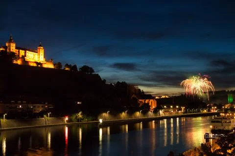 Beautiful shot of exploding colorful fireworks over the water at night in Wurzbu Stock Photos