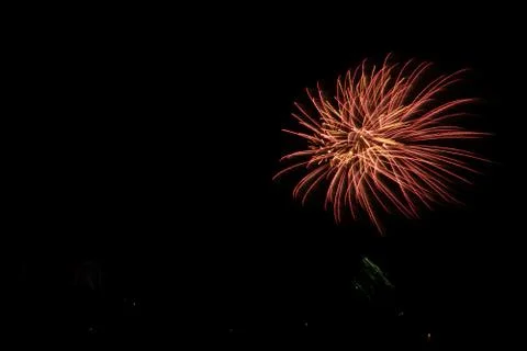 A beautiful shot of exploding red-orange fireworks on a black night sky backg Foto stock