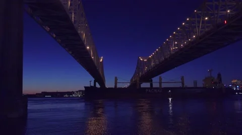 Beautiful shot of a massive cargo ship traveling under the Crescent City Bridge Stock Footage 66546471