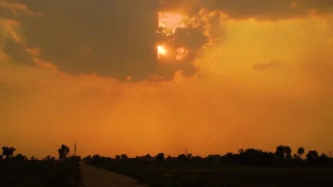 Beautiful shot of sunset behind clouds with silver lining and rays in rural  Stock Footage 210851916