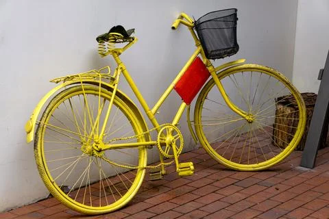 Beautiful side view close up of an old creative bicycle painted yellow. Stock Photos