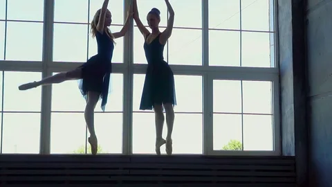 Beautiful silhouettes of ballerinas at a window in studio of the ballet Stock Footage