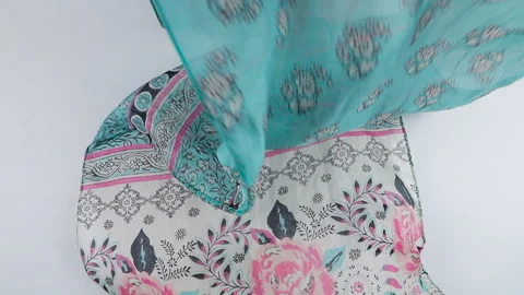 A beautiful silk fabric with a floral pattern falls smoothly in slow motion. Stock Footage 337402606